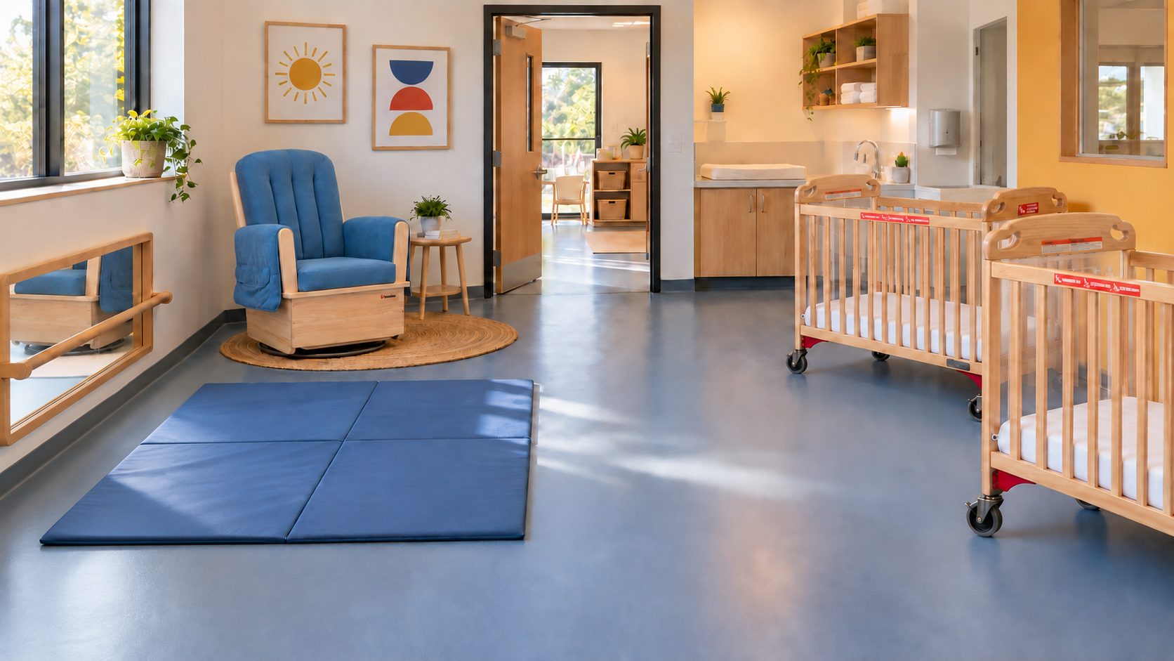 Bright infant classroom setup with wooden cribs, a caregiver glider, organized storage, and an open floor play area.